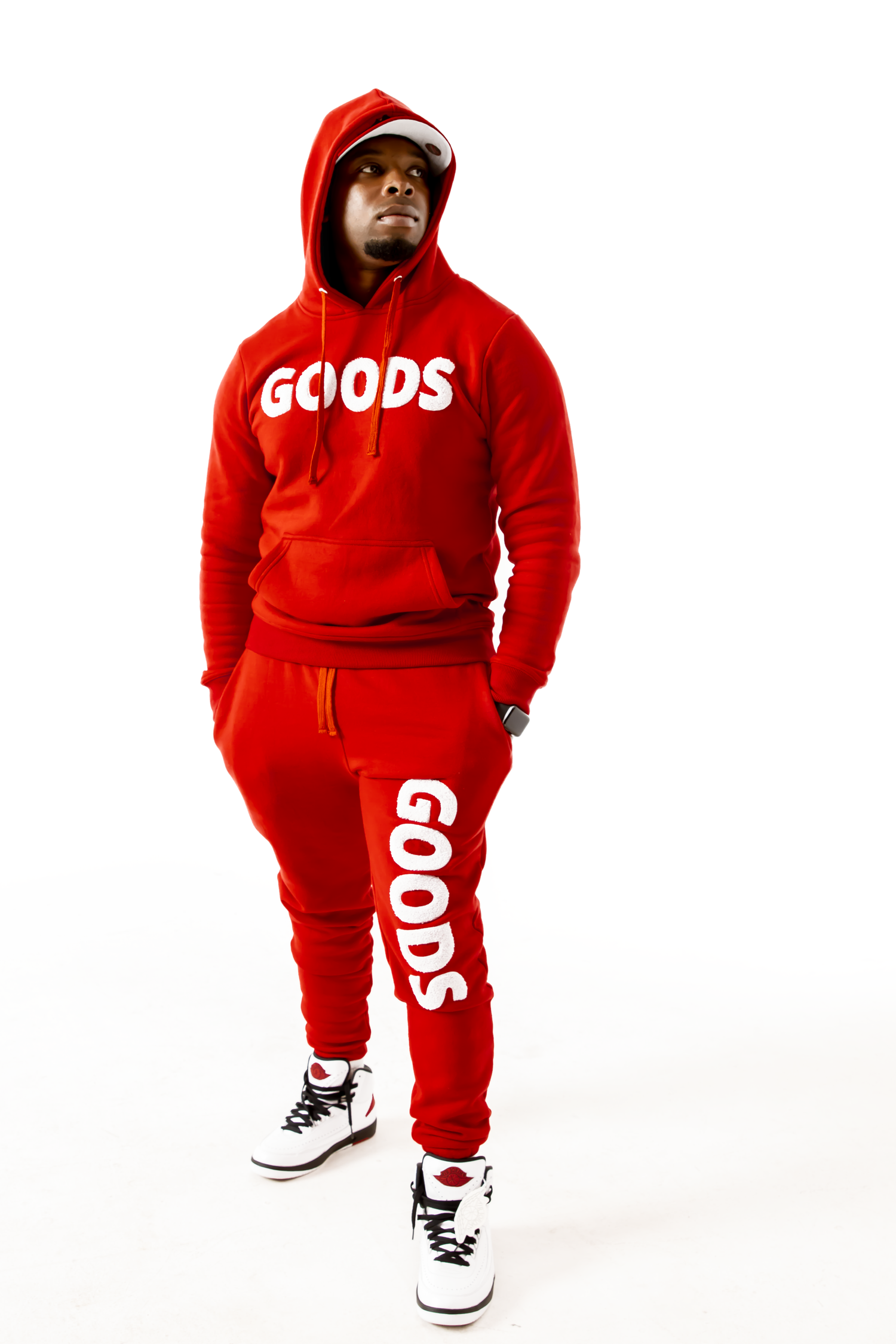 A red hooded sweatsuit made of cotton and polyester, featuring black logo embroidery on the chest and leg.